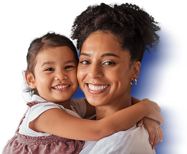 Mom holds daughter while smiling.